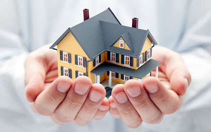 hands holding a drawing of a house